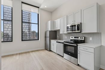 A kitchen with white appliances and cabinets. at LiveWell Apartments, Pittsburgh, PA, 15222